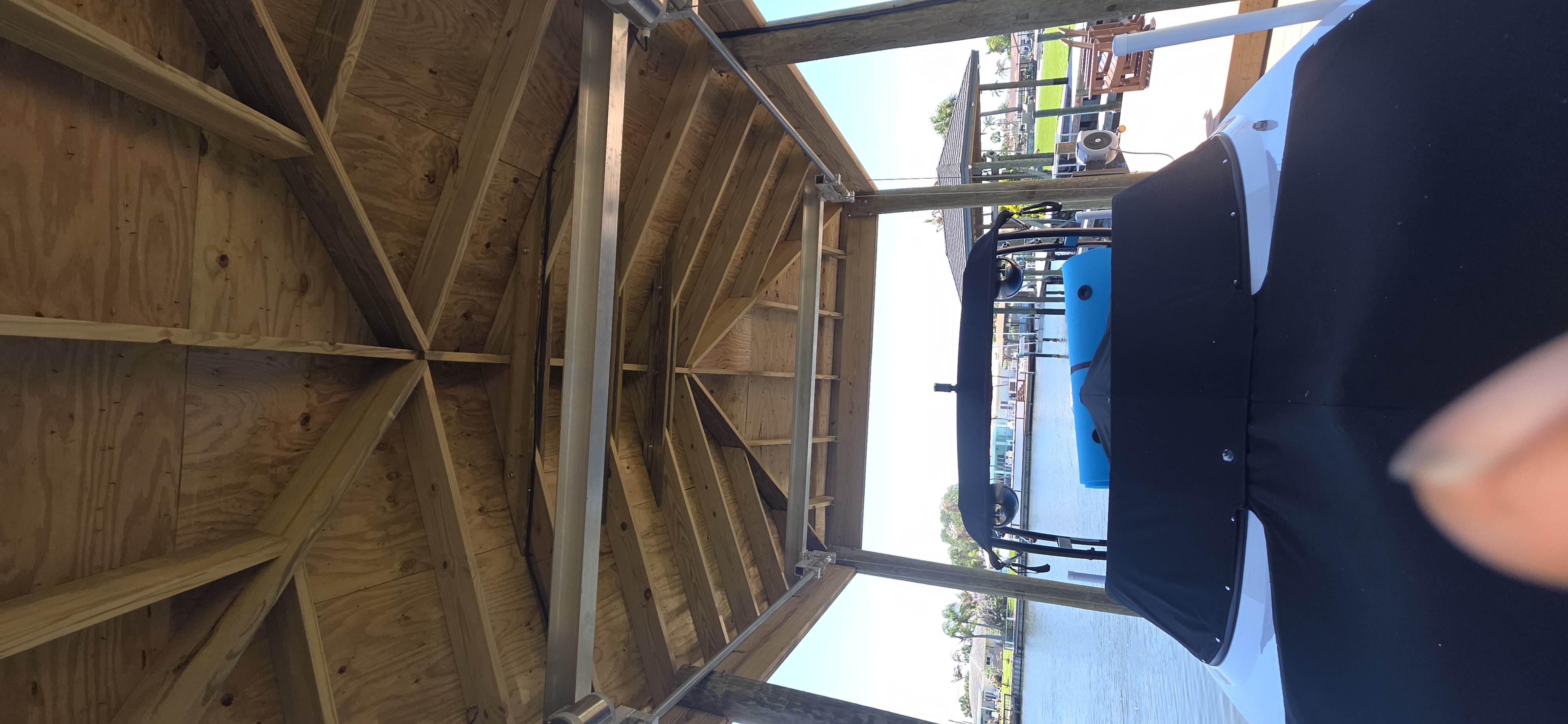 Boat-lift cradle beneath a covered waterfront boathouse
